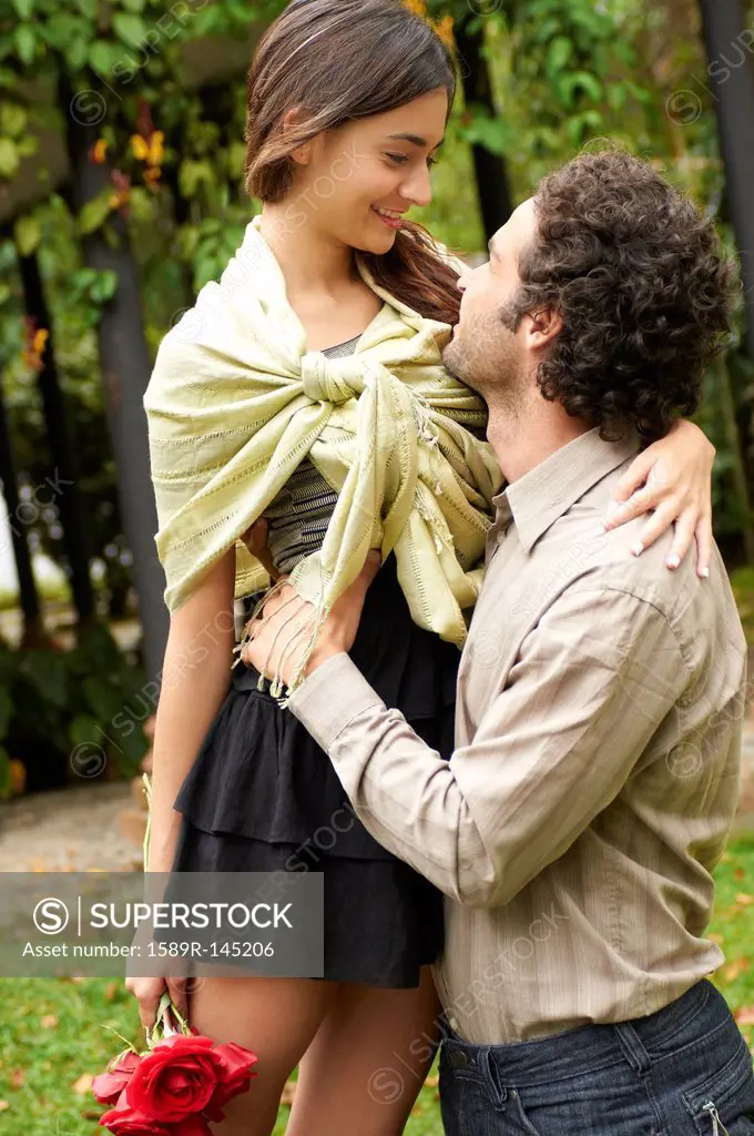 Hispanic couple hugging outdoors