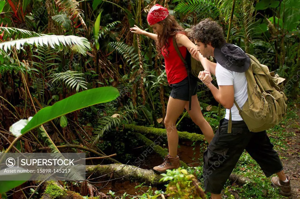 Hispanic couple hiking together in forest