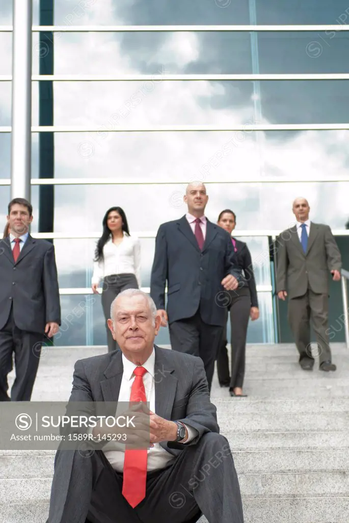 Hispanic business people standing on stairs together outdoors