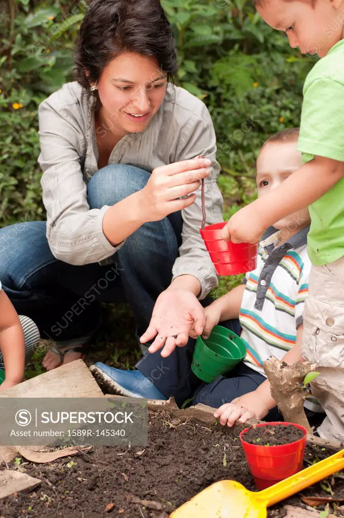 Hispanic mother gardening with sons