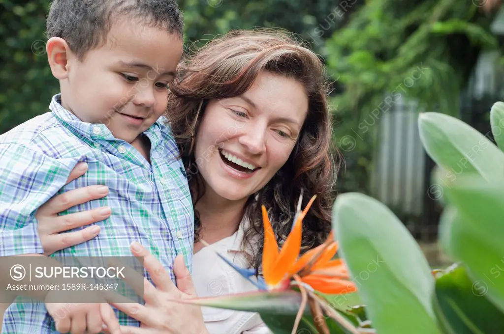 Hispanic mother showing flower to son