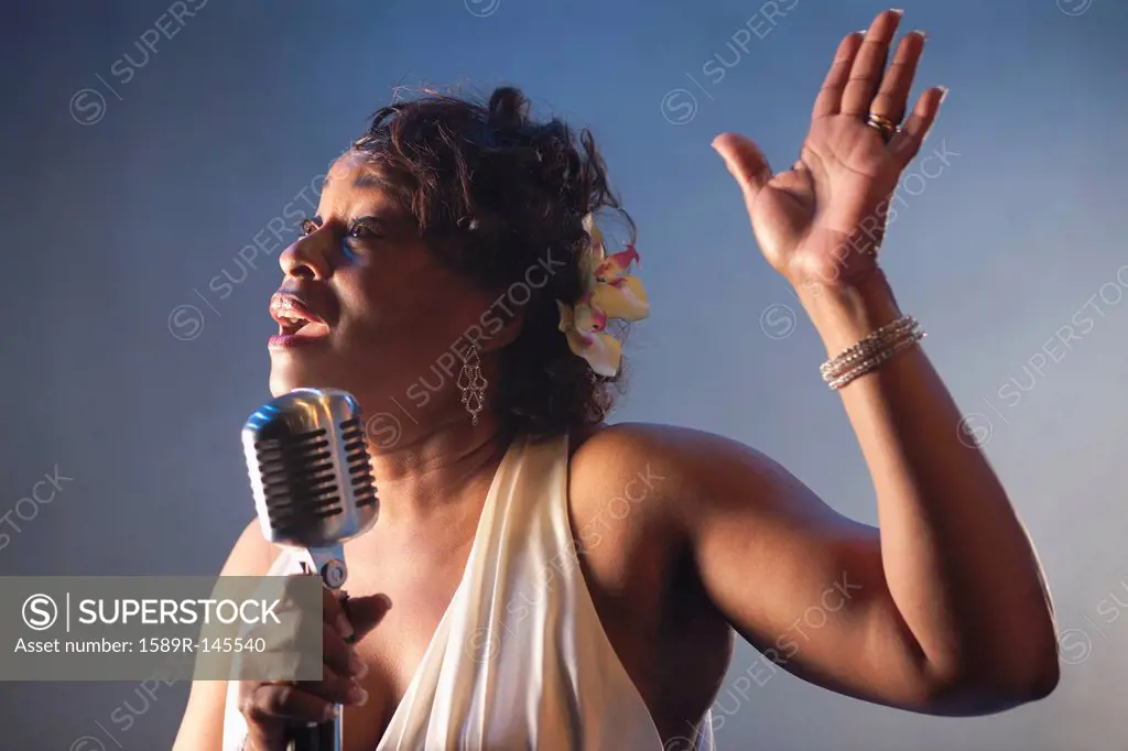 Black woman singing into microphone