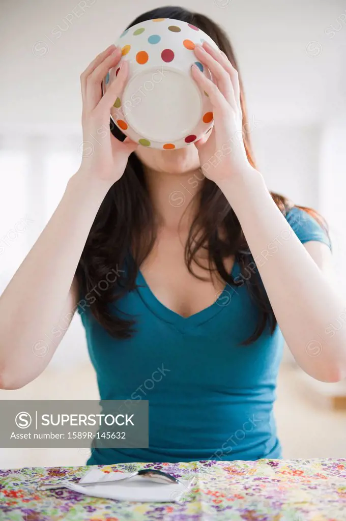 Korean woman drinking from bowl