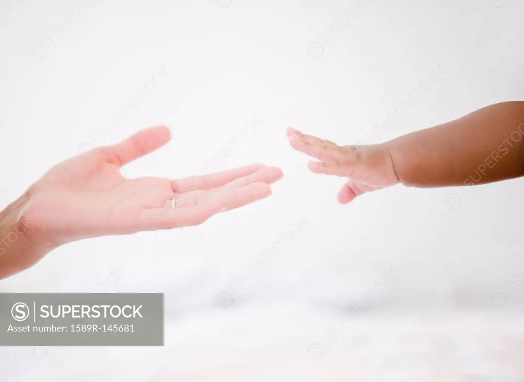 African American woman reaching out to baby boy