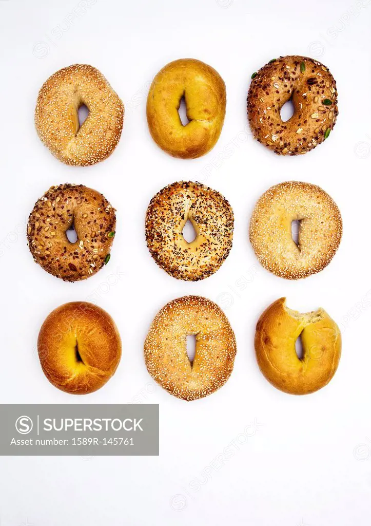 Various bagels, one with bite missing