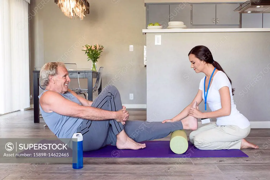 Physical therapist stretching leg of man