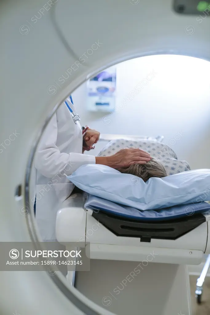 Caucasian doctor comforting patient near scanner