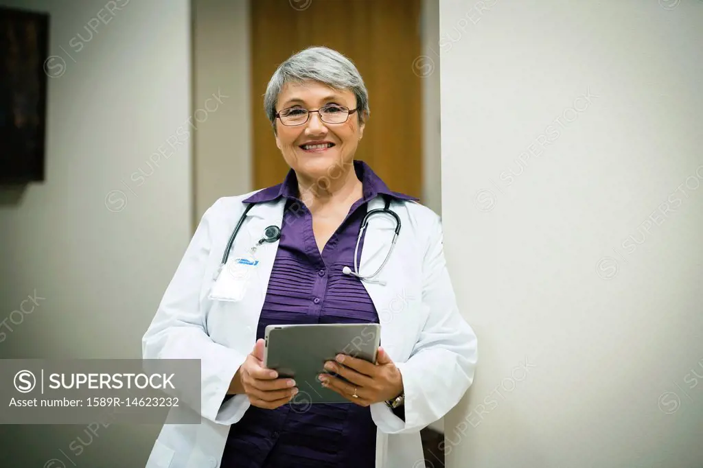 Portrait of smiling mixed race doctor using digital tablet