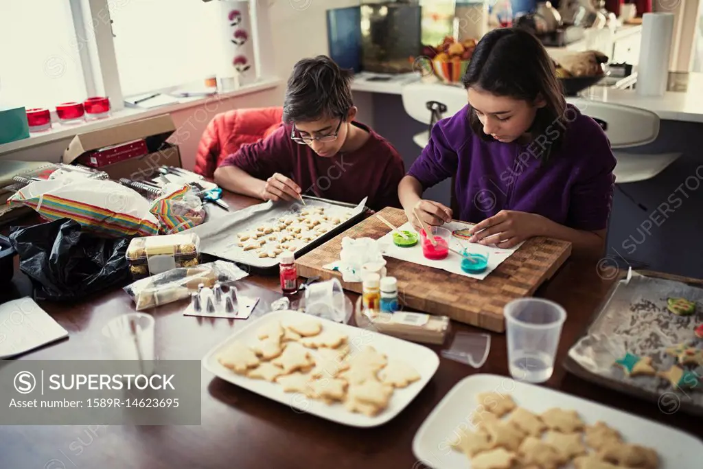 Mixed race brother and sister decorating cookies