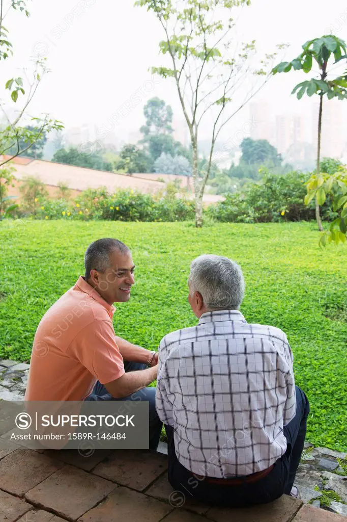 Hispanic father and son talking outdoors