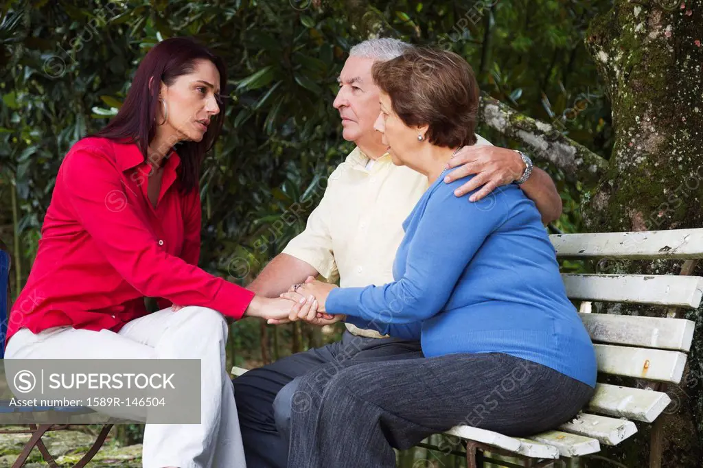 Hispanic woman giving senior Hispanic couple bad news