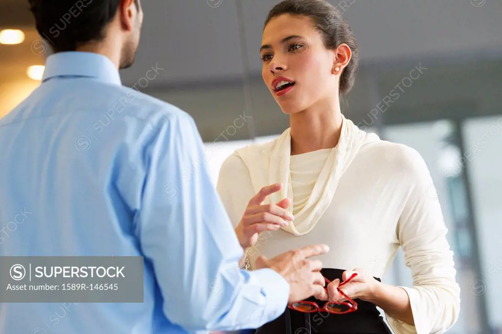 Hispanic business people talking together in office