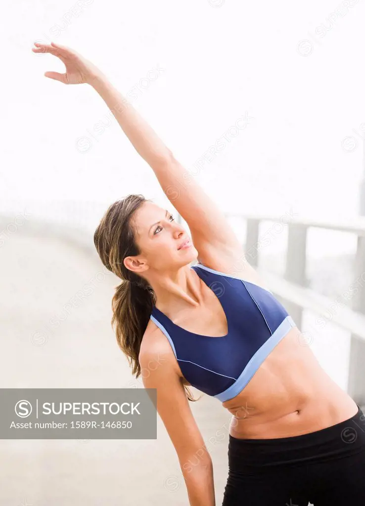 Hispanic woman stretching before exercise