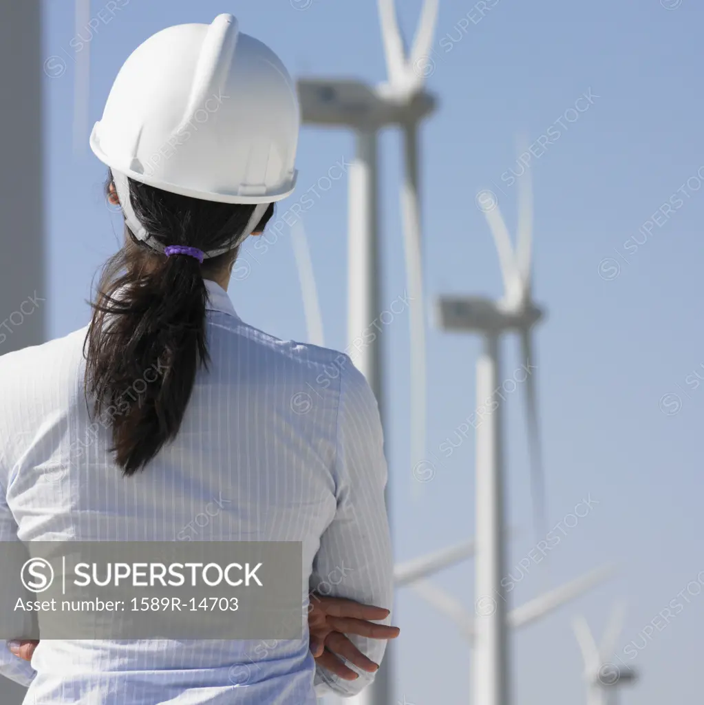 Female engineer examining wind turbines