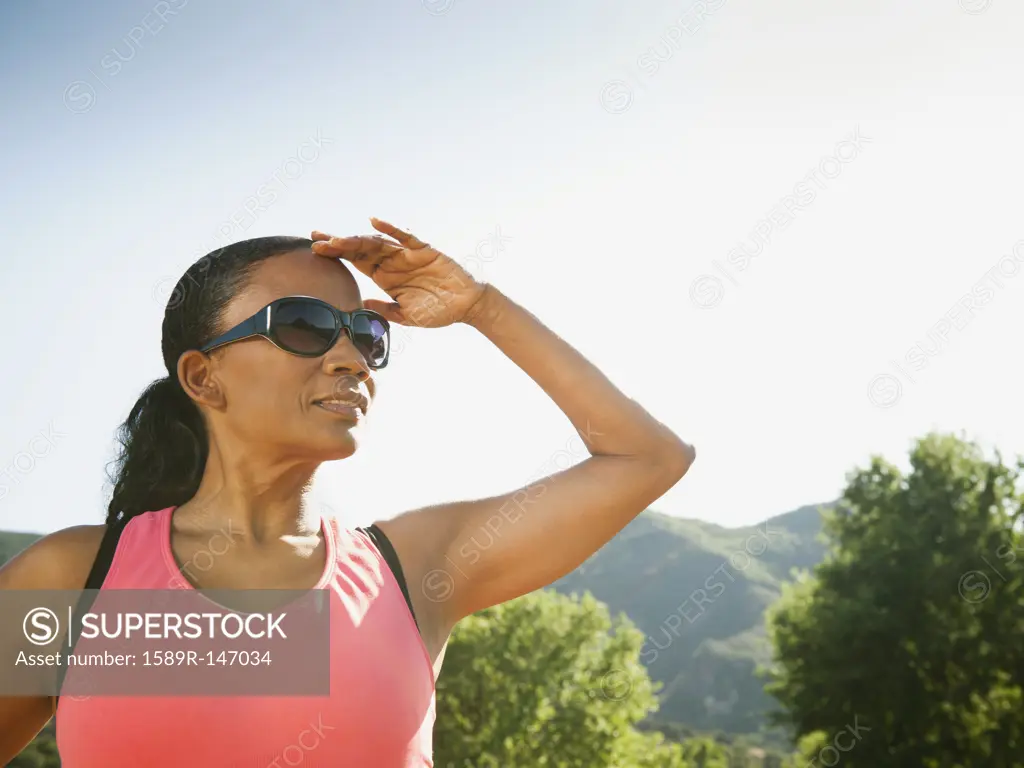 Black woman in sunglasses shielding eyes
