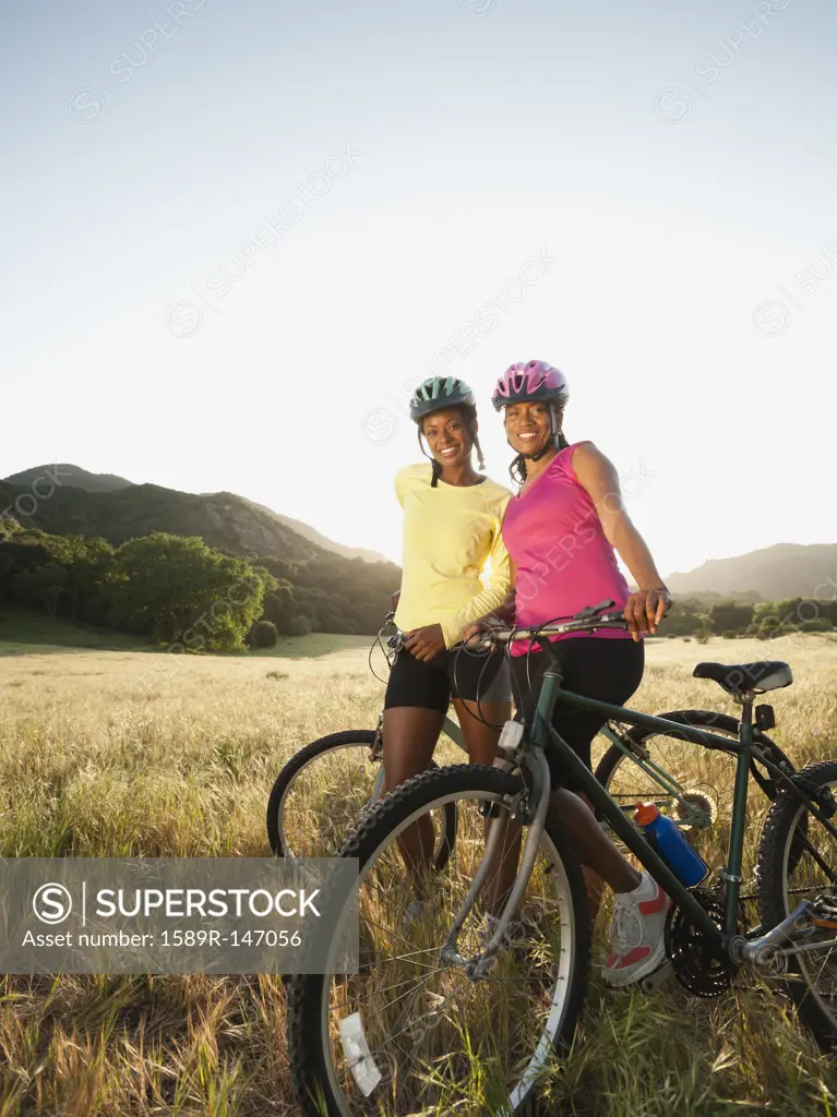 Friends standing in field with mountain bikes