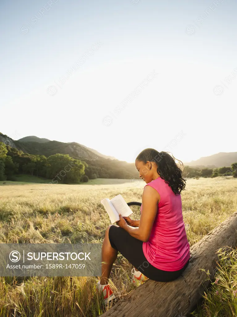 Black woman reading book in remote area