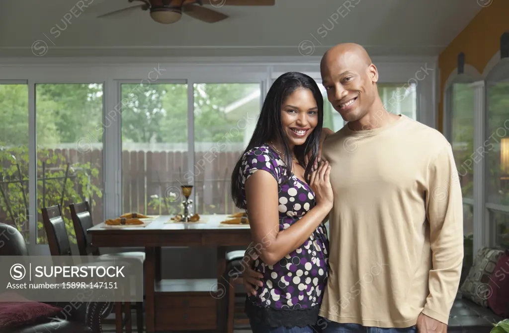 Smiling couple standing in dining room