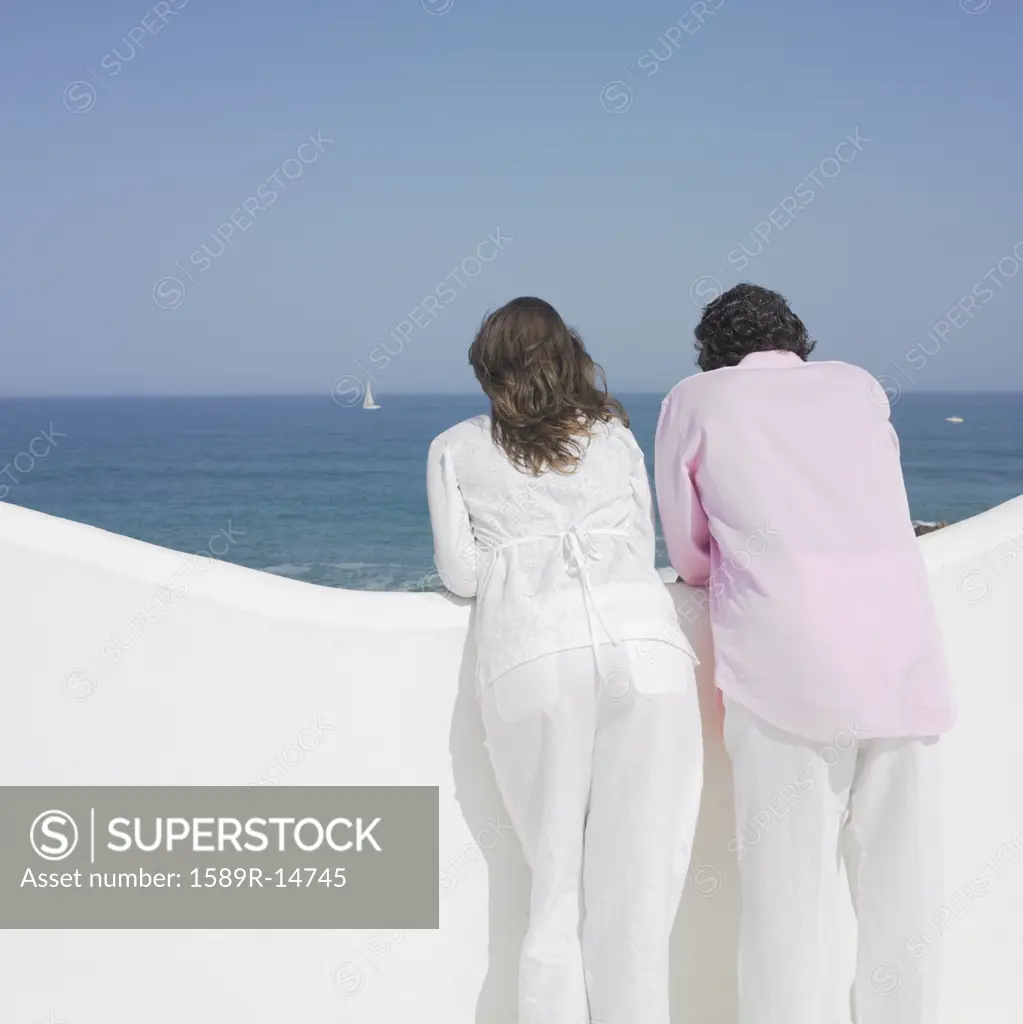 Couple looking over balcony's edge