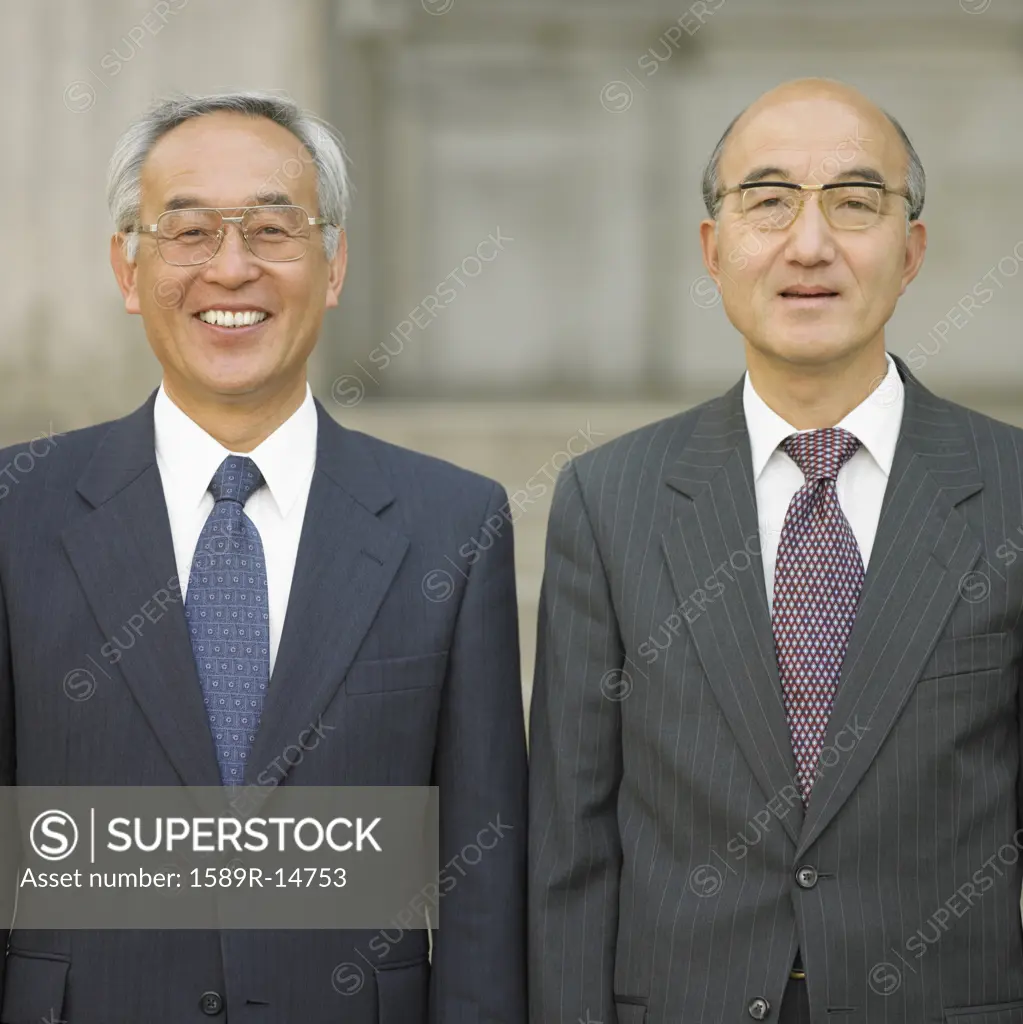 Two Asian businessmen posing posing