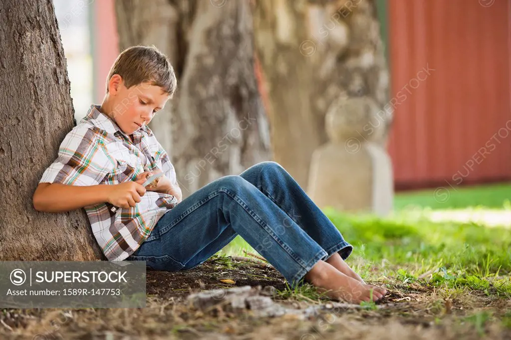 Caucasian boy whittling stick