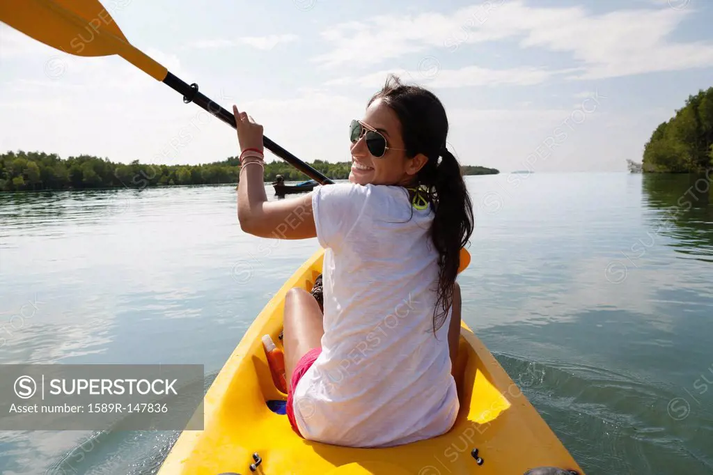 Hispanic woman paddling kayak