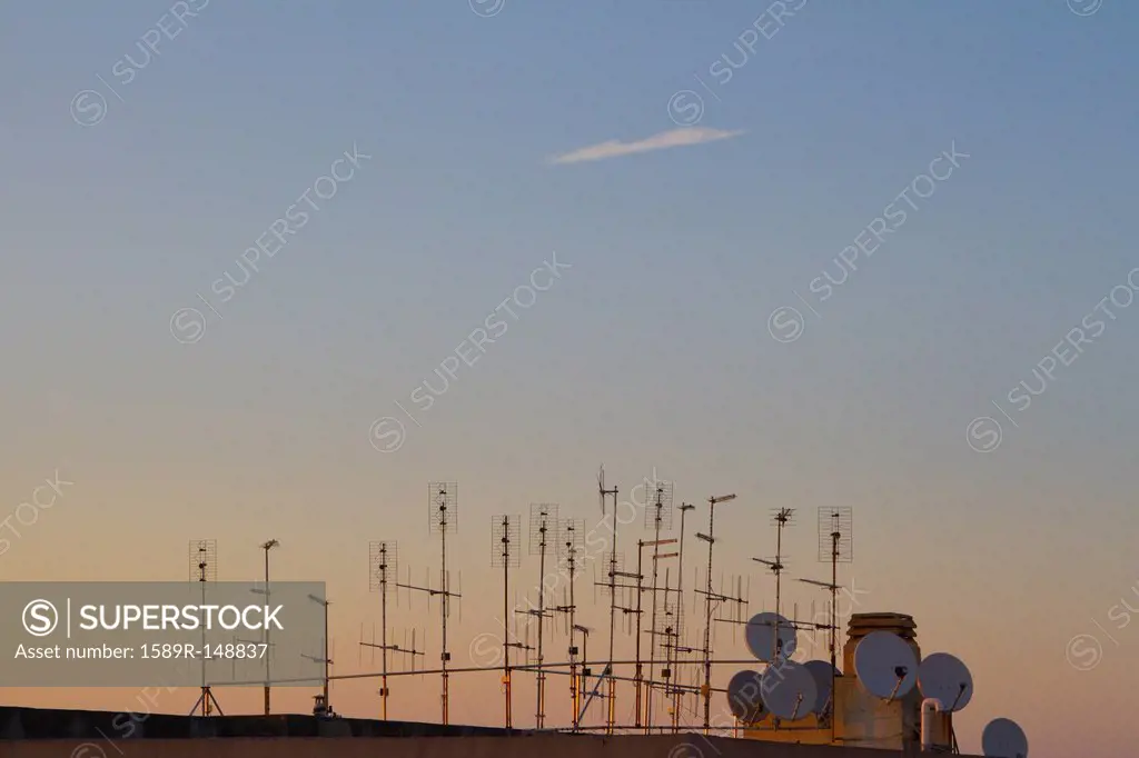 Silhouette of television antennas on rooftop