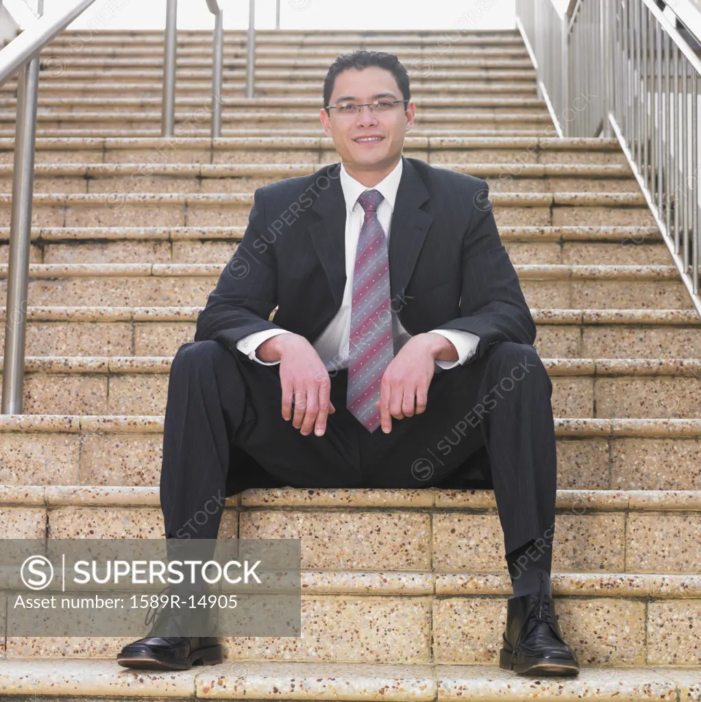 Businessman smiling for the camera on a staircase