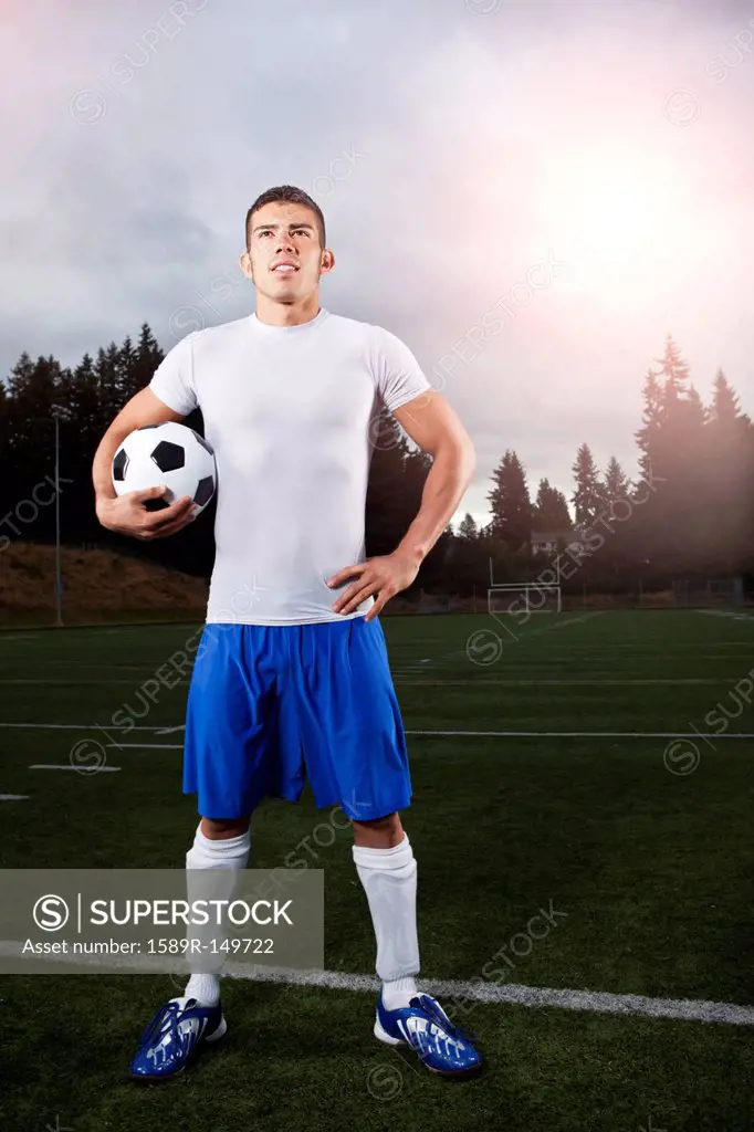 Hispanic athlete standing with soccer ball