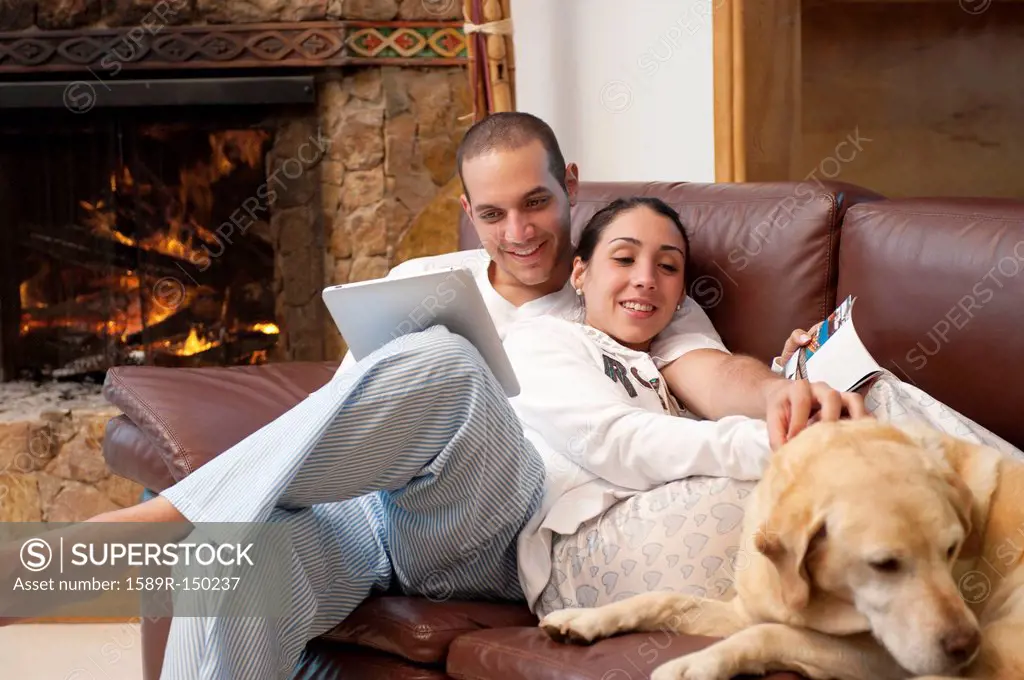 Hispanic couple relaxing on sofa together