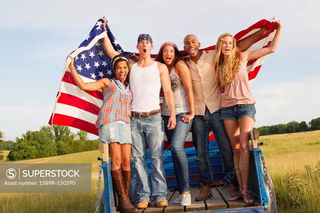 Friends holding American flag on back of truck