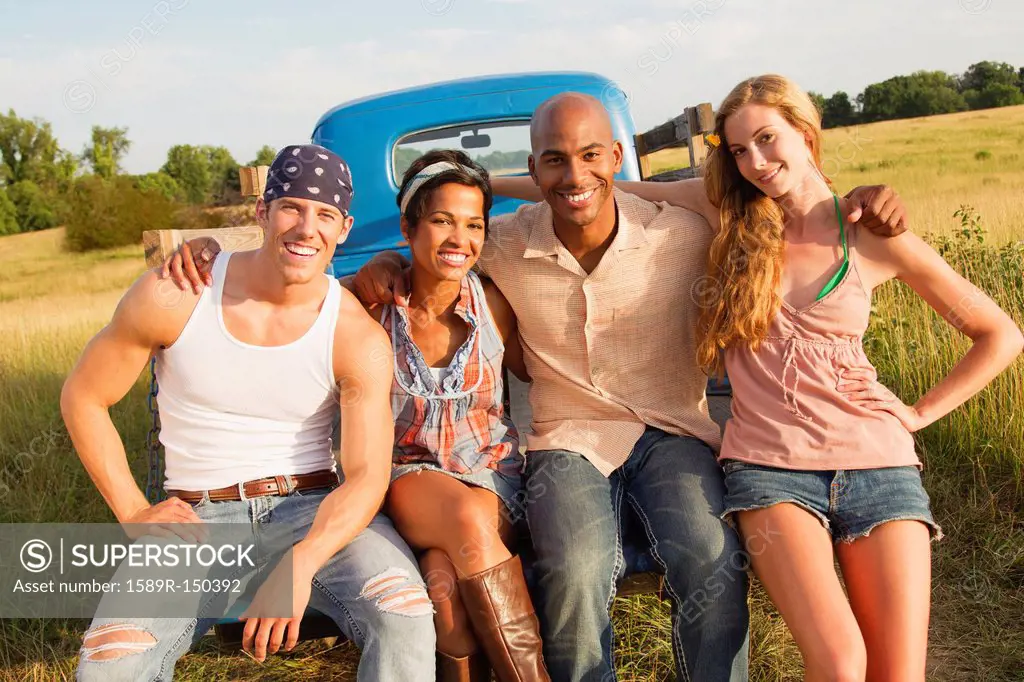 Friends sitting together on back of truck
