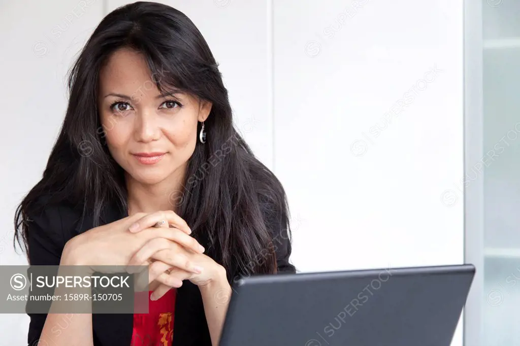 Mixed race businesswoman sitting with laptop