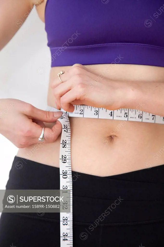 Woman measuring waistline