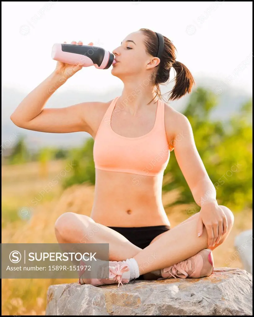 Caucasian woman drinking water after workout