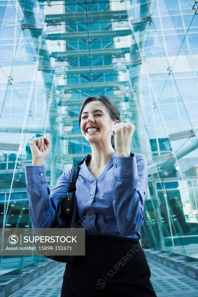 Caucasian businesswoman cheering outdoors