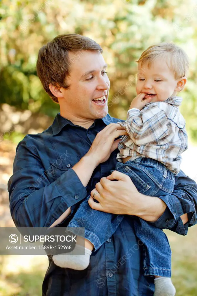 Caucasian father holding son outdoors