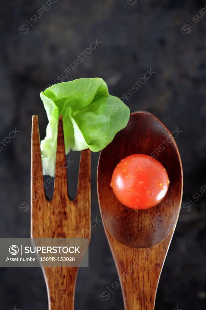 Wooden fork and spoon with lettuce and tomato