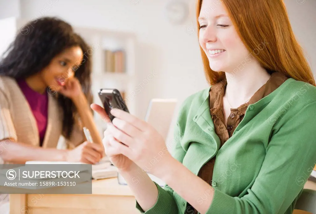 Caucasian woman text messaging on cell phone