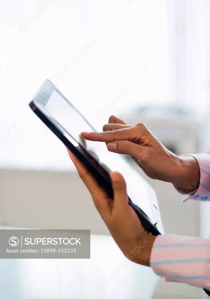 Hispanic businesswoman using digital tablet in office