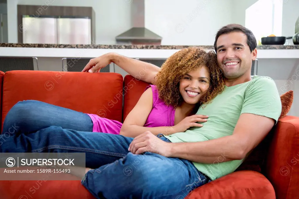 Mixed race couple laying on sofa together