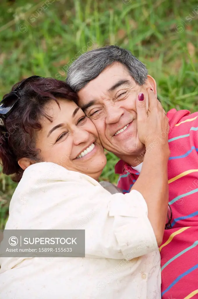Smiling Hispanic couple hugging