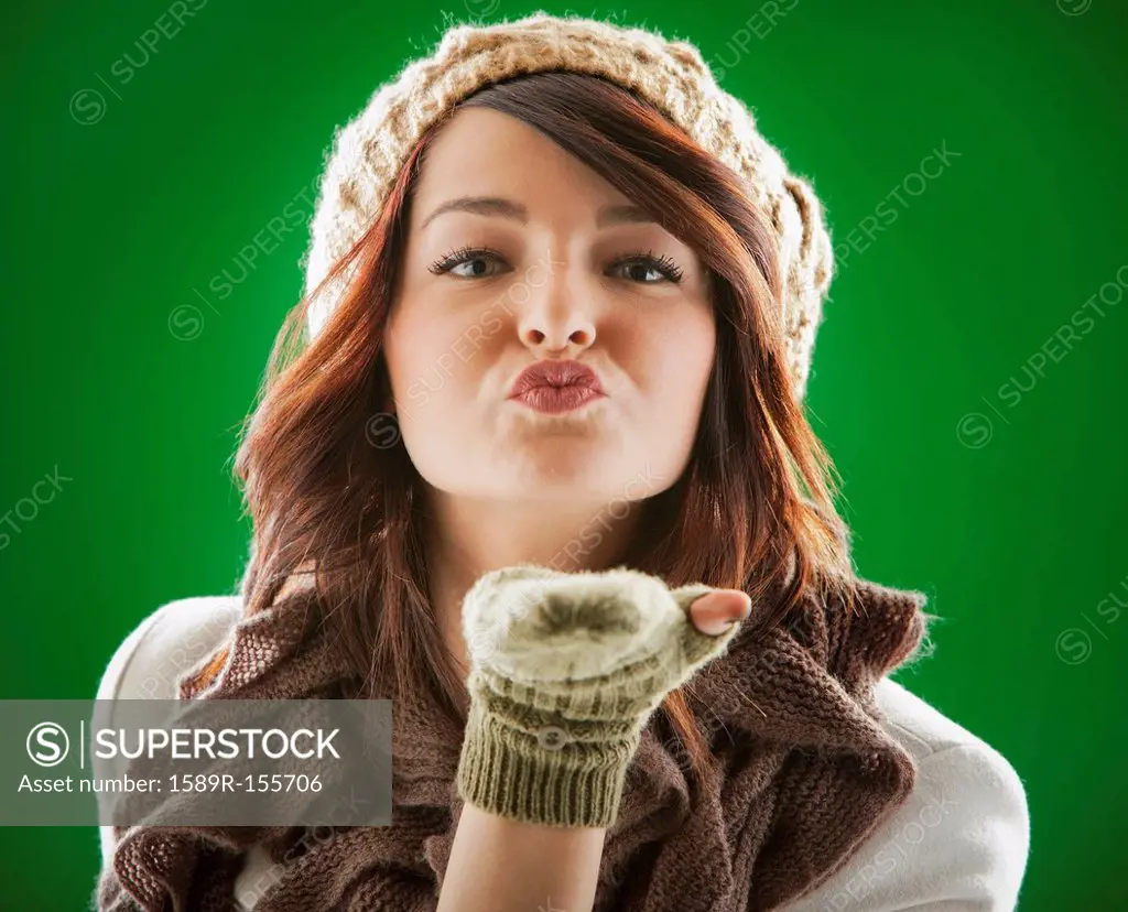 Mixed race woman blowing kisses