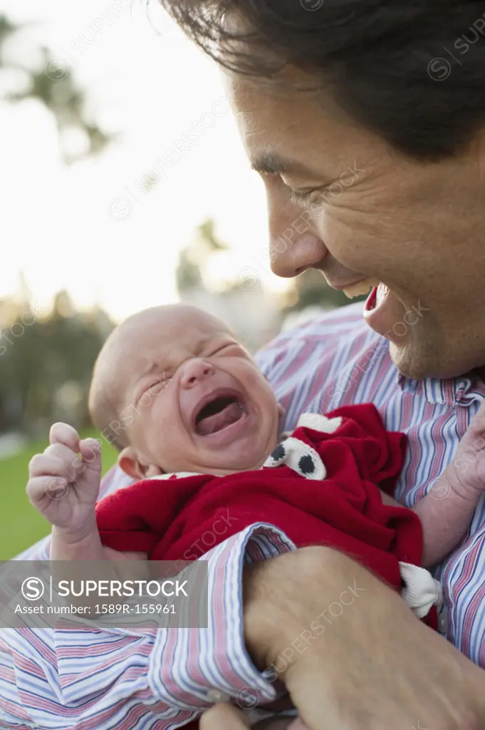Caucasian father holding crying daughter