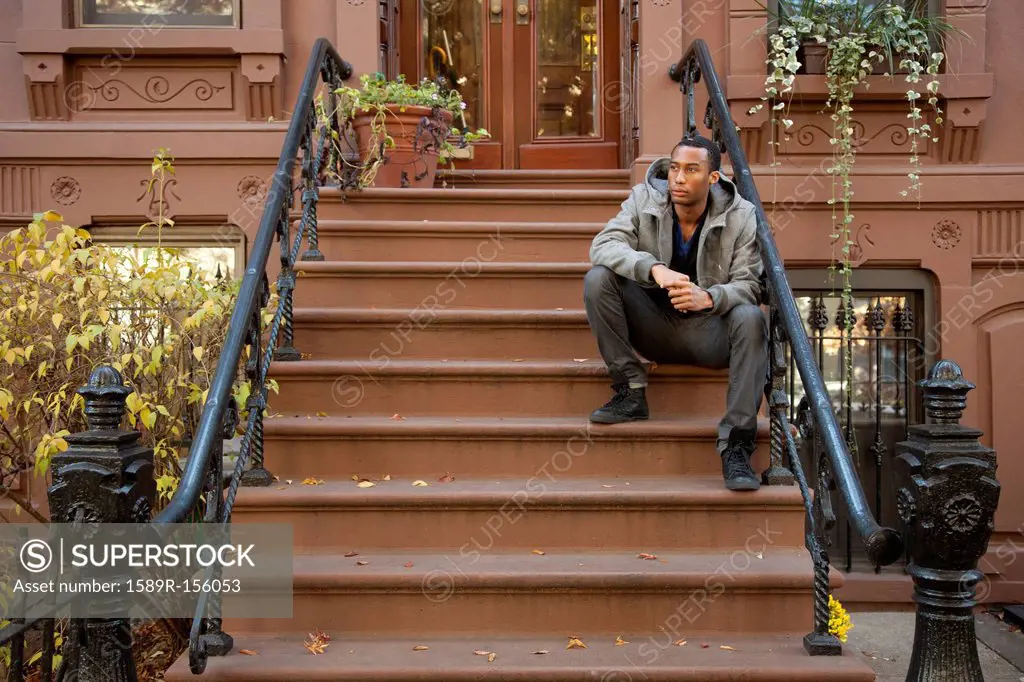 Black man sitting on front stoop