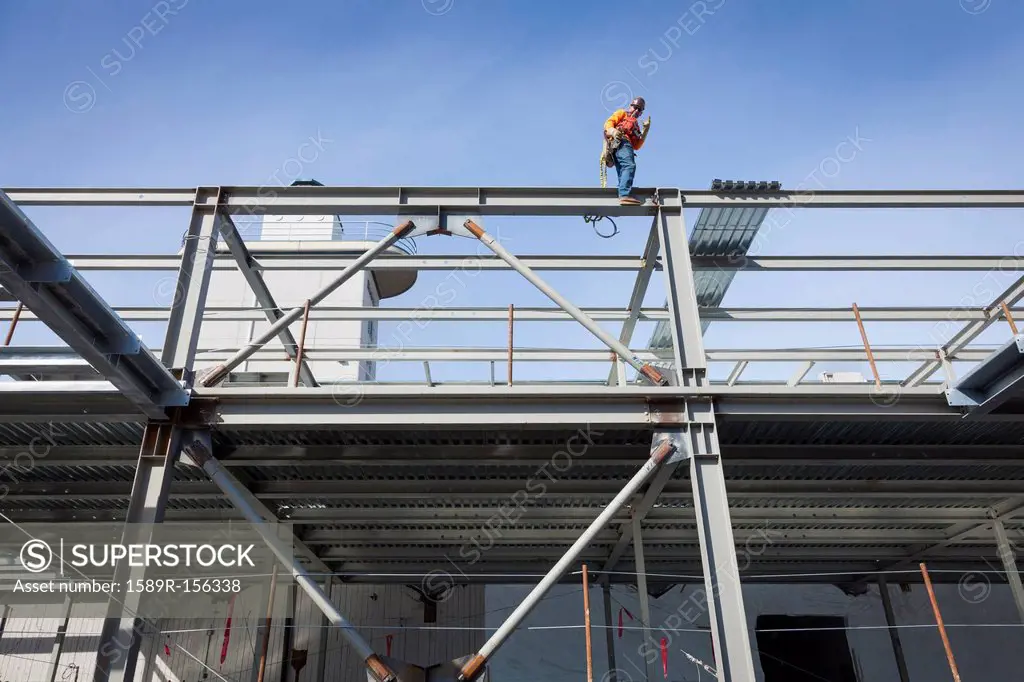 Caucasian construction worker standing on girder