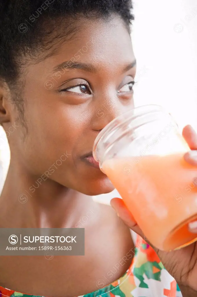 Black woman drinking juice from jar