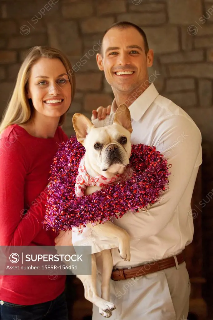 Caucasian couple holding dog