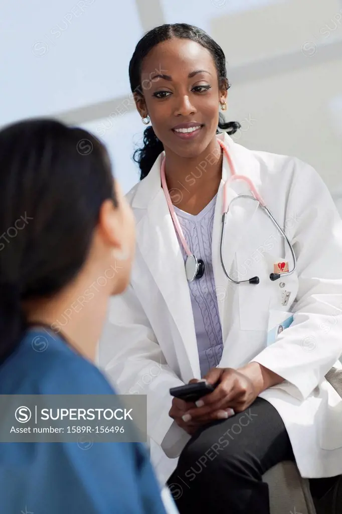 Doctor with cell phone talking to co_worker