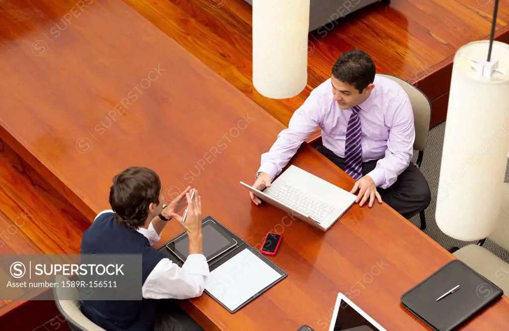Hispanic businessmen having meeting in conference room